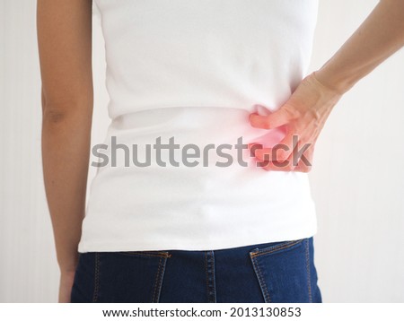 Asian woman suffering from waist  pain. health care concept. closeup photo, blurred.