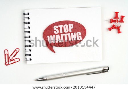 Business concept. On the table there are stationery, a notebook and a red sign with the inscription - STOP WAITING