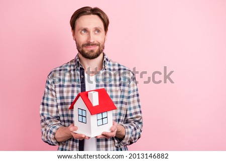 Photo of young man happy positive smile dream look empty space hold home figure moving isolated over pink color background