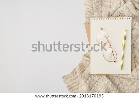 Top view photo of two reminders stylish glasses pen and sweater on isolated white background with copyspace