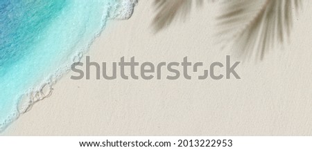 Tropical beach background with sea waves, white sand, palm tree shadows - summer holiday background. Travel and beach vacation, copy space for text. Royalty-Free Stock Photo #2013222953