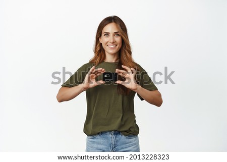 Shopping. Smiling middle aged woman showing credit discount card, looking happy, recommend contactless paying, buying smth, standing over white background