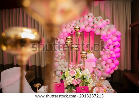 The wedding decoration on the table with the glittering glasses on the table and the pink balloons 