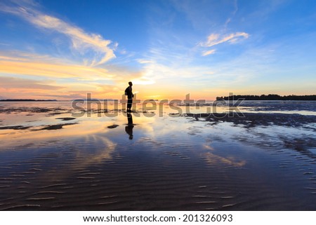 Man standing near the beach looking at sun rising