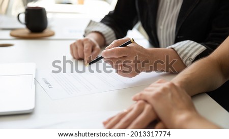 Hands of elderly female client, mature business leader, senior businesswoman reading and signing contract with assist of lawyer, solicitor. Executive checking legal document for affixing signature