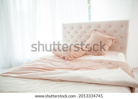 Cozy bedroom interior, Large bed by the window in pastel colors,