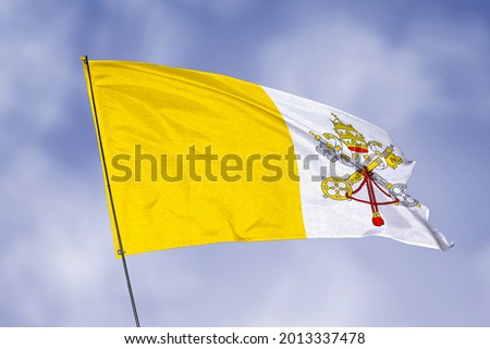 Vatican flag isolated on sky background. National symbol of Vatican. Close up waving flag with clipping path.