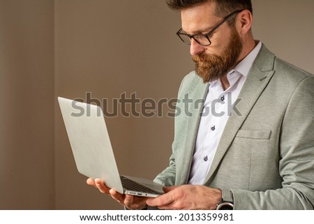 Portrait of successful businessman in office with laptop