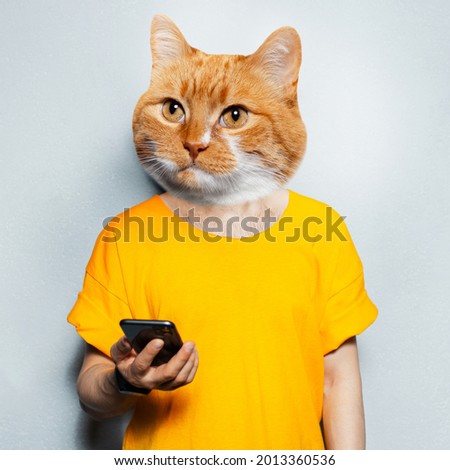 Cat's head on male body in yellow, using smartphone, textured grey background.