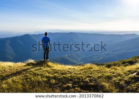 unrecognizable adventurous man looking at the horizon in mountain