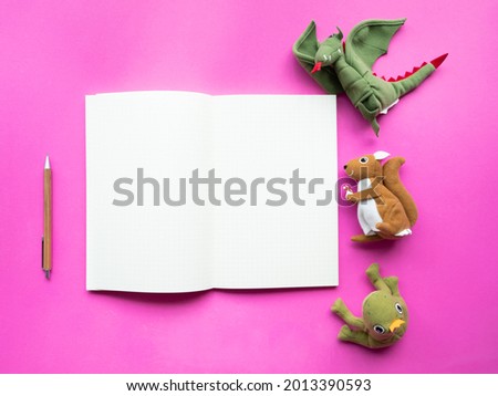 Empty blank notebook with animal dolls on pink background.Creative story telling concept.
