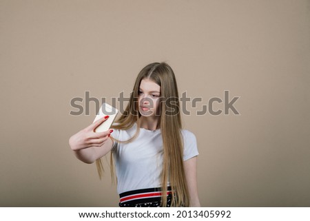 Portrait of a young attractive woman making selfie photo on smartphone isolated on white background