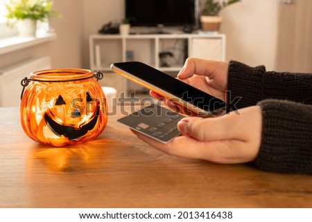 Halloween online shopping, sales and discounts promotions on mobile phone. Halloween online shopping, sales and discounts promotions during the spooky day. Online shopping at home in october. Black fr