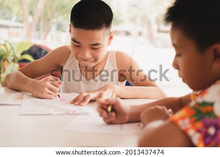 Excited emotion face of disabled child on wheelchair and his friend with indoor activity at home, Competition picture, Lifestyle of disability kid learning in homeschool doing math exercises.