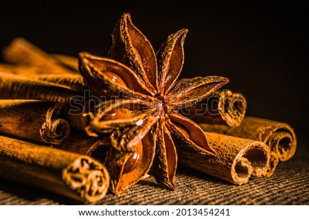 Christmas baking spices, cinnamon sticks and anise stars for Christmas cake, cookies or mulled wine on a black background, macro photo.
