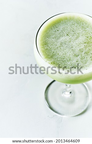 Close up of top Creamy smoothie and refreshing summer shake Iced Matcha Latte served in Champagne Saucer glass on white background
