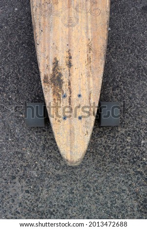 Photo of a background with a wooden longboard on the pavement. Top view
