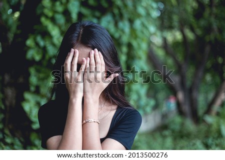 An inconsolable and devastated young woman weeps uncontrollably. Covering face with hands. Loss of parent or friend at funeral. Royalty-Free Stock Photo #2013500276