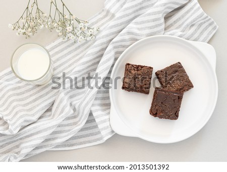 Pieces of brownies with a glass of milk