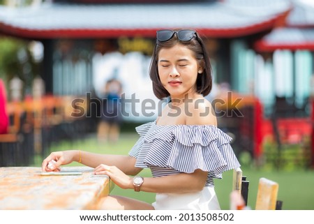 A smart woman short hair in soft dress and white short pants on cafe hight hill, she is happy and like on trip for travel and take a photo