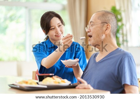 A caregiver who assists the elderly with meals Royalty-Free Stock Photo #2013530930