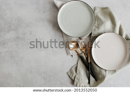 Plates mockup with copy space.Modern minimal table place setting neutral beige color on gray concrete background top view. Modern kitchen.Scandinavian style tableware.Business food brand template. Royalty-Free Stock Photo #2013552050