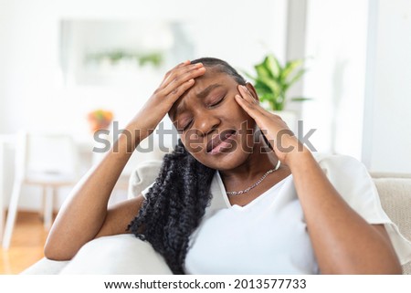 Portrait of unhappy African-American woman suffering from toothache at home. Healthcare, dental health and problem concept. Stock photo