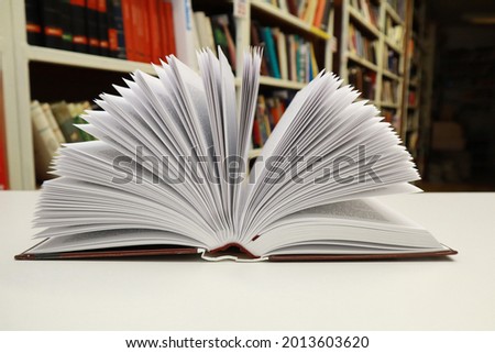 Open book on table in library