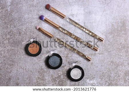 Makeup palette top view with brushes and lipstick
