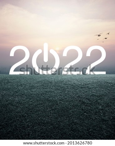 2022 start up business flat icon with green grass field over aerial view of cityscape at sunset, vintage style, Happy new year 2022 cover concept