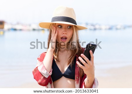 Young pretty woman in summer holidays at beach making a selfie