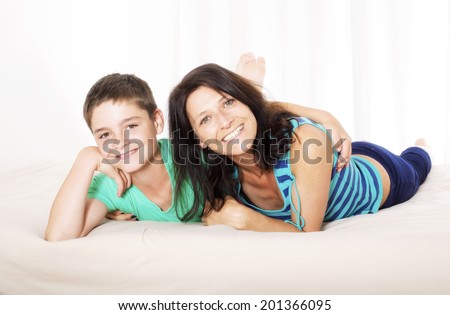 mother and her son lying in bed and smiling