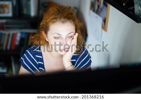 photo of a stressed young woman working late on a computer