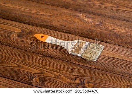 Brush On Wooden Board With Wood Stain Top View. Board Repair. Royalty-Free Stock Photo #2013684470