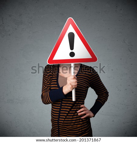 Young woman holding a red traffic triangle warning sign in front of her head