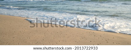 Seascape view Panorama:Sandy coastline with white turquoise Sea morning waves.Summer travel white sand .Close up waves on the beach.Texture and Pattern wallpaper backgrounds.