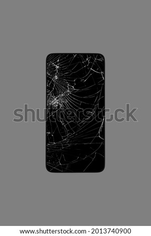 smartphone with a broken screen isolated on a gray background top view