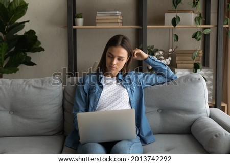 Attractive 25s woman put wireless computer on laps do shopping from home look at laptop screen search helpful information, purchasing remotely use web e-services, modern tech for fun or study concept