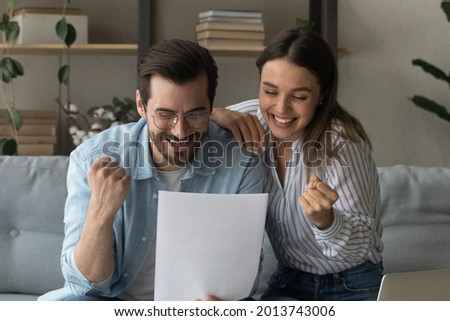 Beautiful couple read letter notification news from bank feel overjoyed clench fists make yes gesture, succeed goal, celebrate incredible offer received, loan approval looking happy. Success concept Royalty-Free Stock Photo #2013743006