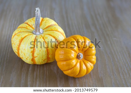 Two pumpkins on a wooden desk