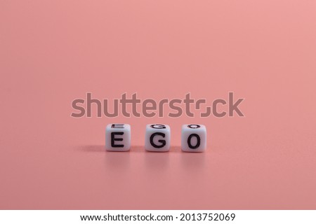 Alphabet beads with text EGO isolated on pink background Royalty-Free Stock Photo #2013752069