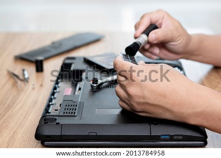 Computer literacy repair men holding memory of laptop and use bush cleaning with computer repair and tool equipment on table 