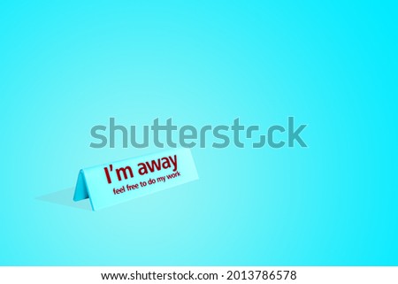 The sign on the table with the inscription "I'm away feel free to do my work" on a gentle blue background.