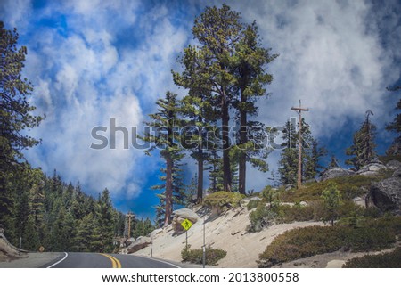 Watch for walkers sign along curvy highway with pine trees on Western size of Lake Tahoe California