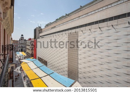 Awnings to protect people from the Spanish summer sun on Preciados street and Madrid's Puerta del Sol in the background