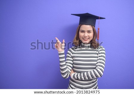 A portrait of young woman graduated over blue background 