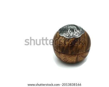 Isolated pictrue of round wooden box, the silver plate is on the top, elephant picture show on it.