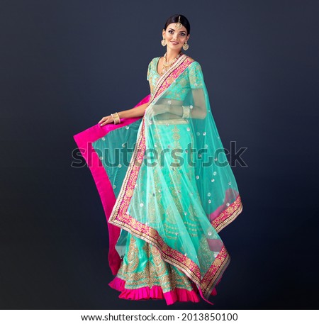 Portrait of beautiful indian girl. Young India woman model with kundan jewelry set. Traditional Indian costume lehenga choli or sari Royalty-Free Stock Photo #2013850100