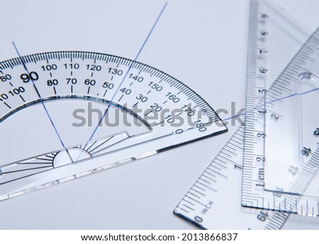 Shool materials for drawing: bevel, square and angle meter on a white paper. Back to school
