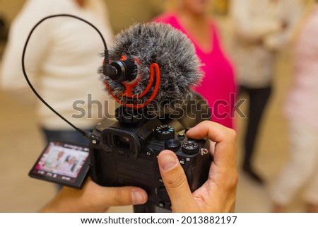 Production movie video concept : Professional videographer or photographer holding setting mirrorless camera shooting take photo or video for recording at outdoor.